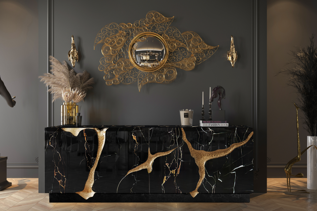 Dark luxury hallway featuring a black marble sideboard with gold tree-branch accents below a gold filigree mirror.
