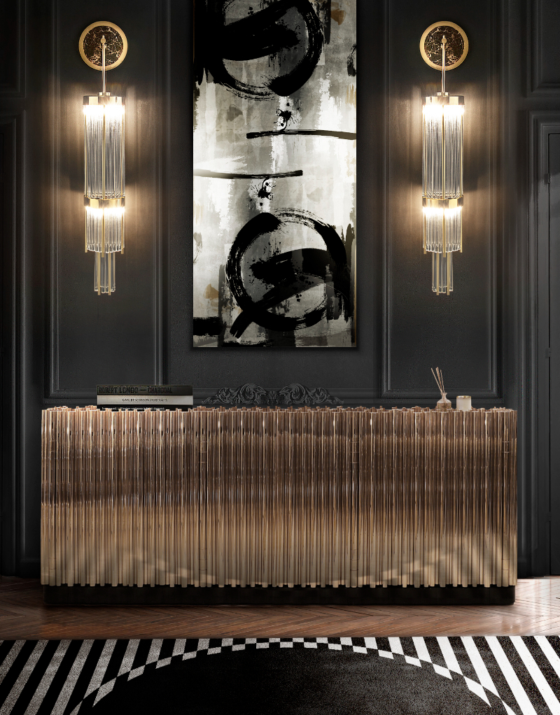 Luxury sideboards-  dark grand entrance, wall lamps, picture frame, luxurious gold sideboard and a black and white rug