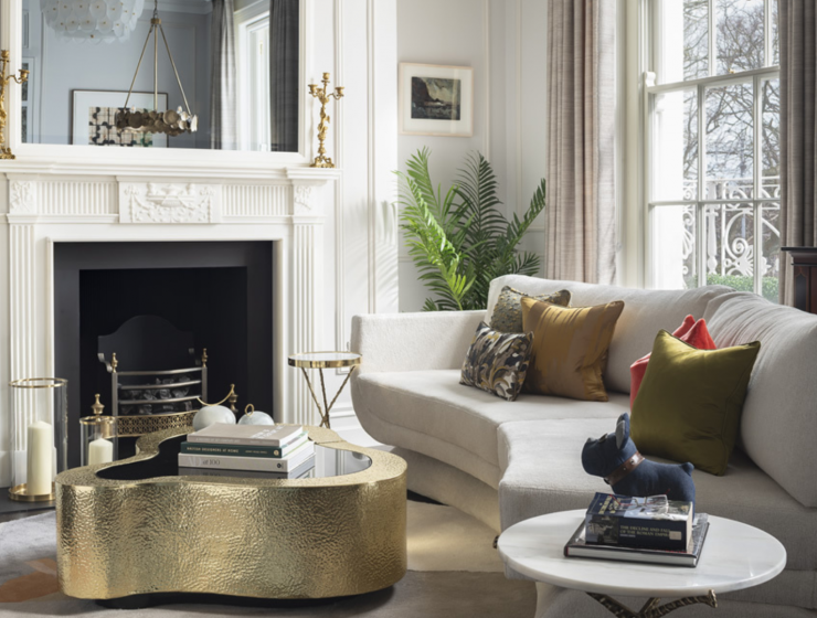 contemporay living room with white a white sofa and a curved gold center table