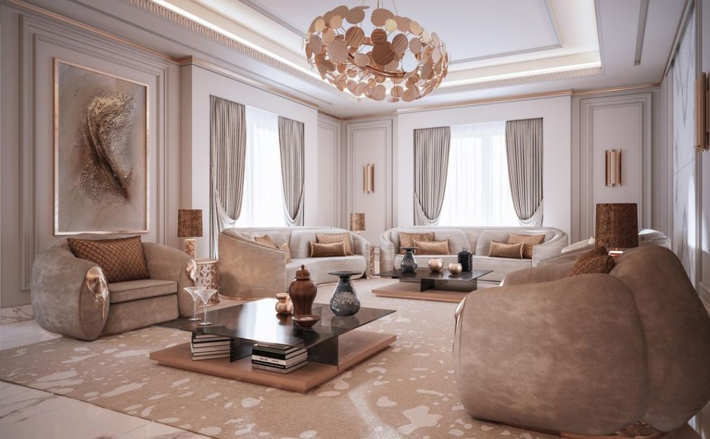 sala de estar com poltrona nude, lustre dourado e sofá curvo creme