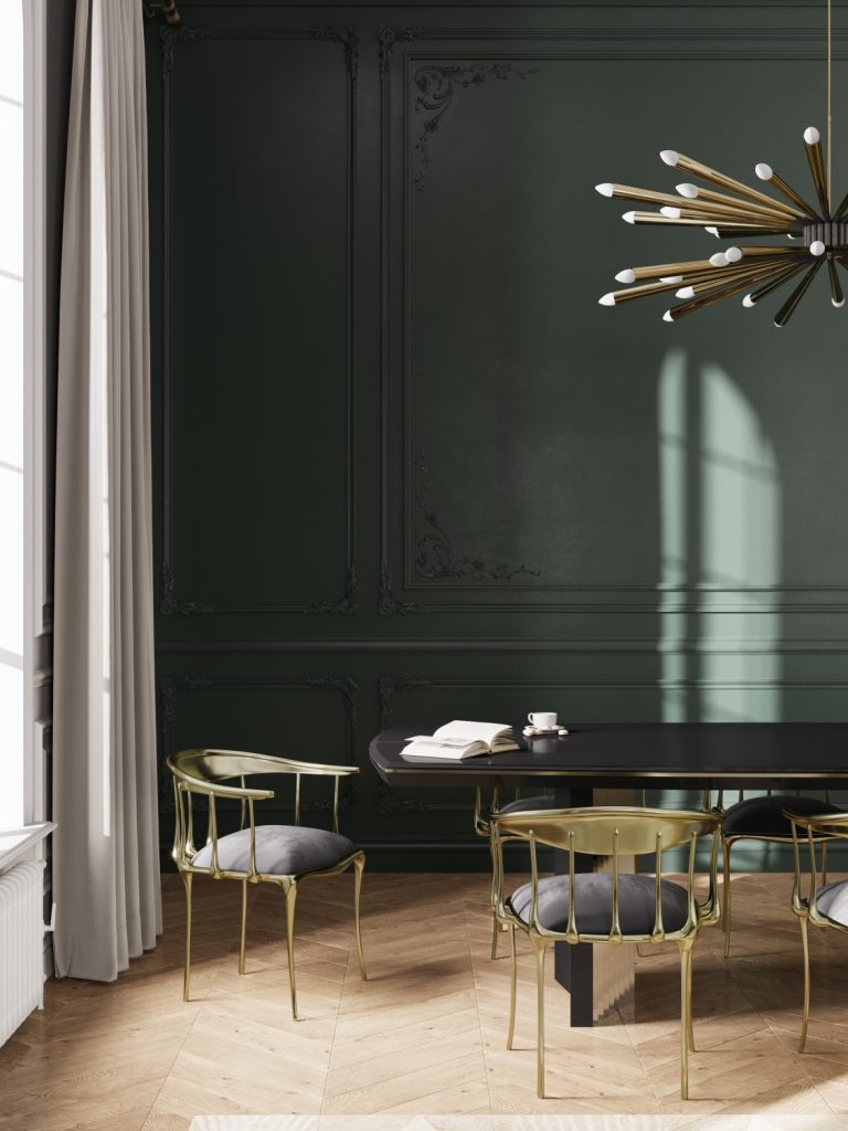 green dining room with  agold suspension lamp, a black dining table and black and gold dining chairs