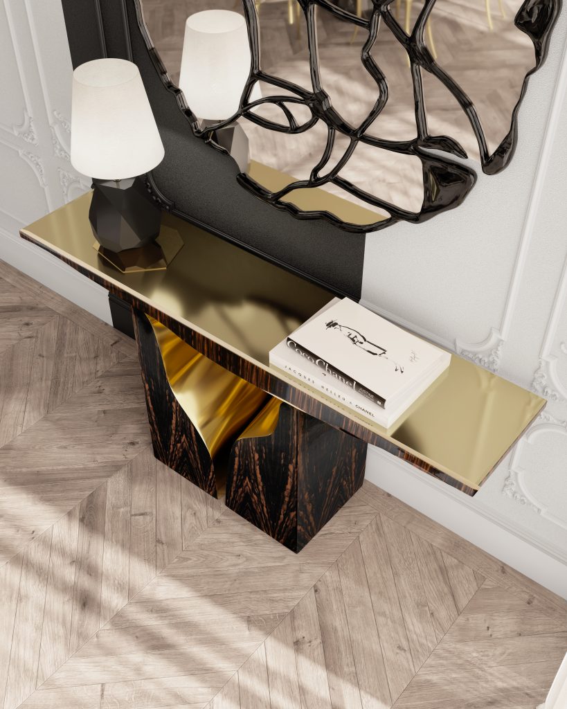 Gold and Black: Elegant Entryway with Black and Gold Decor: A luxurious entryway featuring a sleek black console table with gold accents, adorned with a stylish gold vase and black decorative items. Above the table, a large, gold-framed mirror reflects the light from an exquisite gold chandelier hanging from the ceiling. The walls are decorated with sophisticated black and gold patterned wallpaper, enhancing the overall elegance of the space. A plush black rug with gold detailing lies on the floor, welcoming guests into the opulent interior.