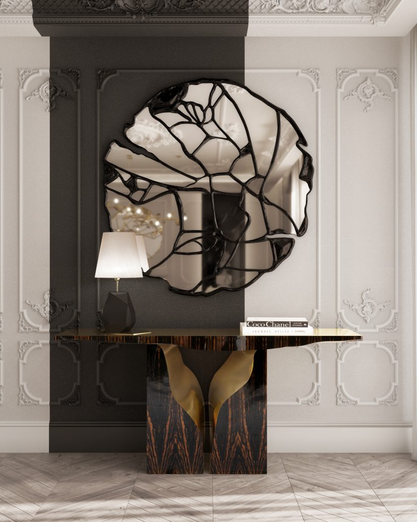 Gold and Black: Elegant Entryway with Black and Gold Decor: A luxurious entryway featuring a sleek black console table with gold accents, adorned with a stylish gold vase and black decorative items. Above the table, a large, gold-framed mirror reflects the light from an exquisite gold chandelier hanging from the ceiling. The walls are decorated with sophisticated black and gold patterned wallpaper, enhancing the overall elegance of the space. A plush black rug with gold detailing lies on the floor, welcoming guests into the opulent interior.