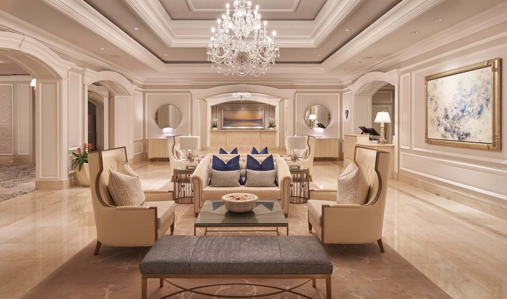 Opulent luxury hotel lobby with chandelier and beige armchairs, interior designers in Hong Kong