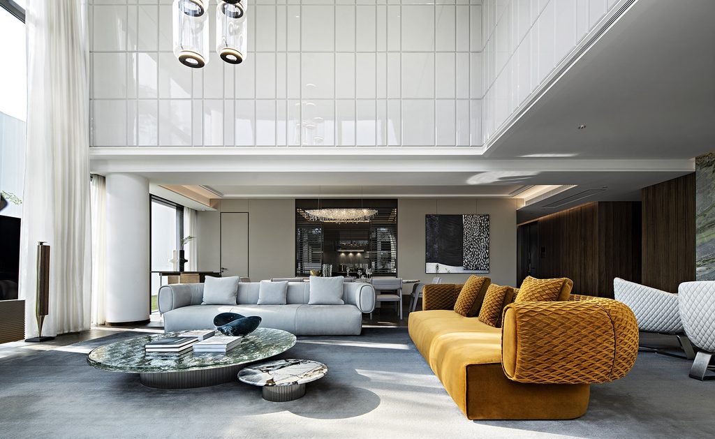 Double-height modern lounge with mustard yellow sofa, interior designers in Hong Kong