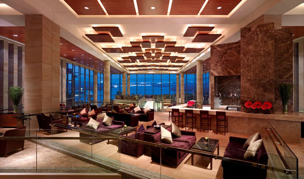 Luxe lounge with purple sofas and panoramic ocean view, interior designers in Hong Kong