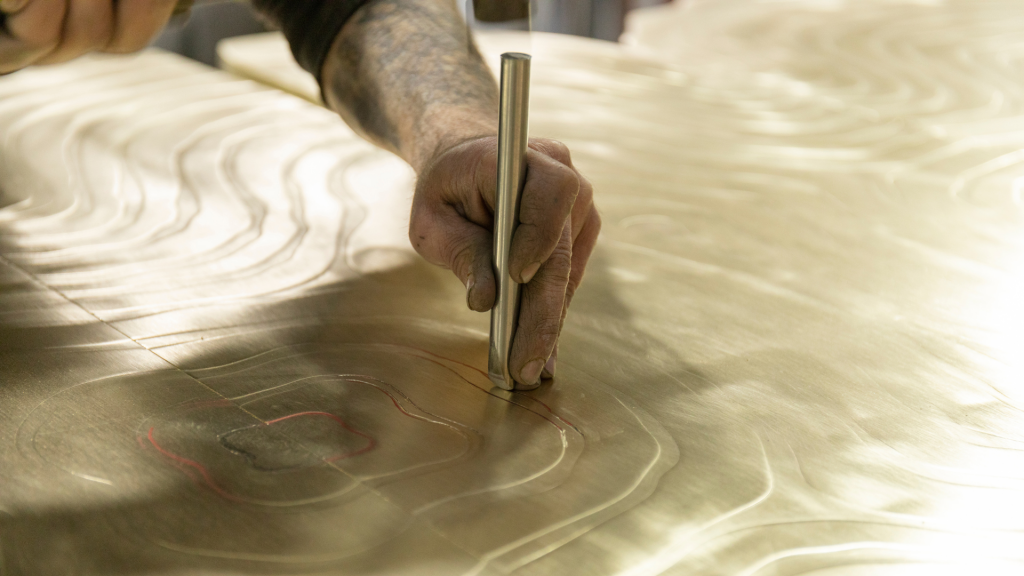 Close-up of the Fortuna Dining Table in production, showcasing intricate metalwork and Portuguese craftsmanship