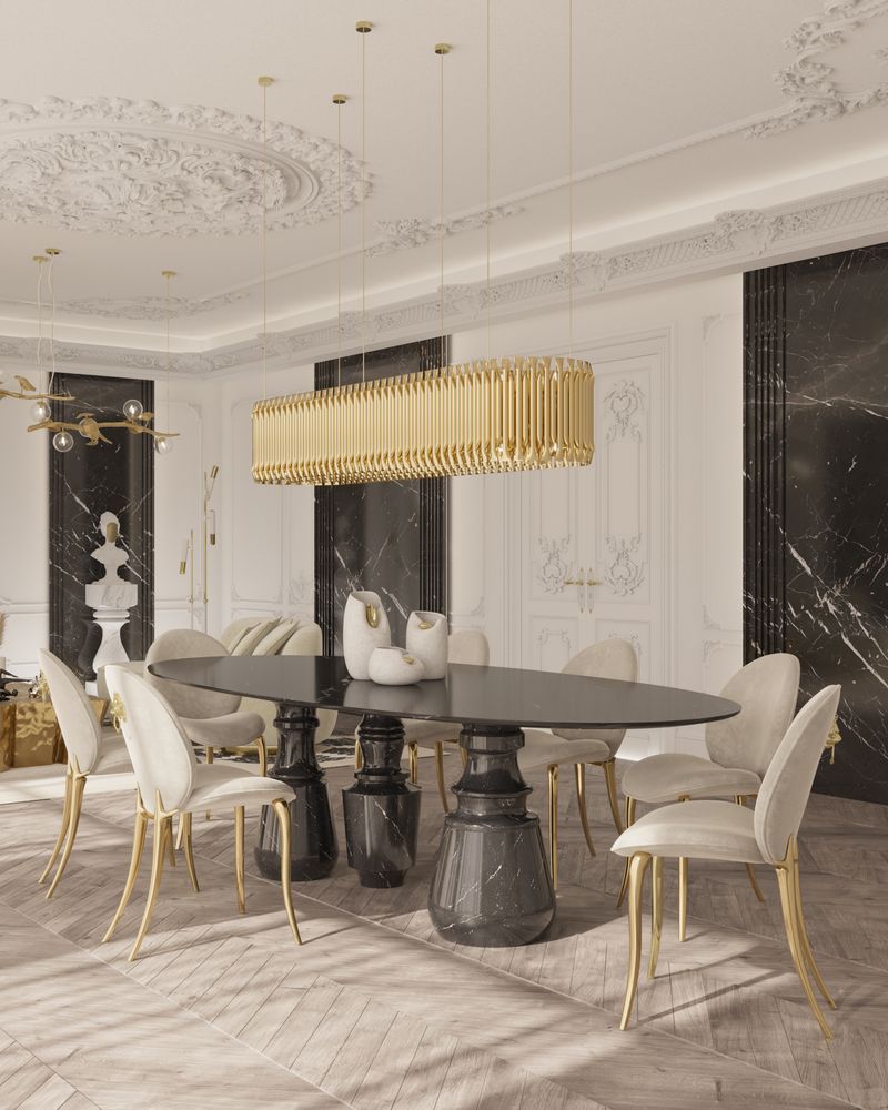 cadeira creme e dourada, mesa de jantar preta, luminária suspensa dourada, parede branca e preta, telhado branco, cadeiras de design com piso de madeira