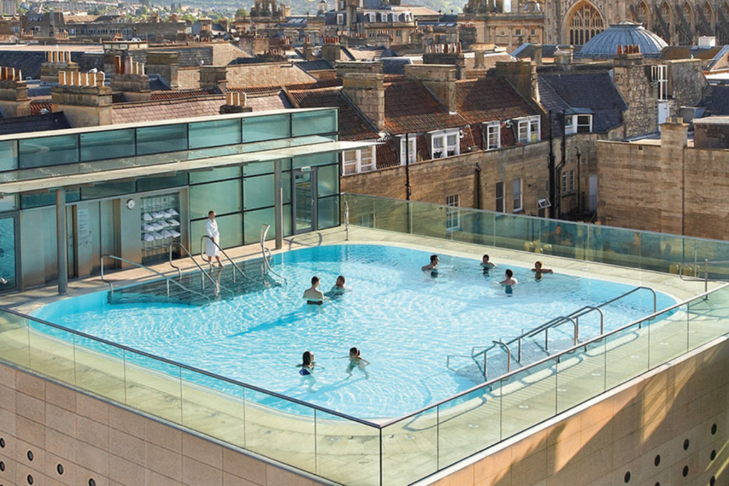 Luxury Thermal Baths in Europe, Modern rooftop infinity pool overlooking the historic skyline and rooftops of Bath, England.
