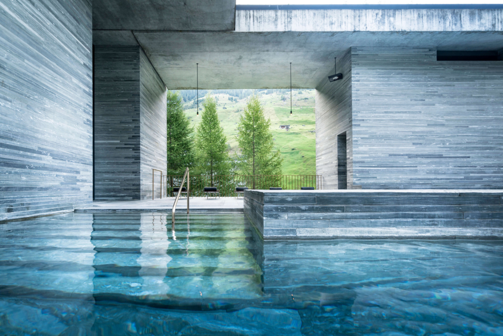 Luxury Thermal Baths in Europe, Minimalist grey stone architecture of 7132 Therme Vals with a view of pine trees in Switzerland.