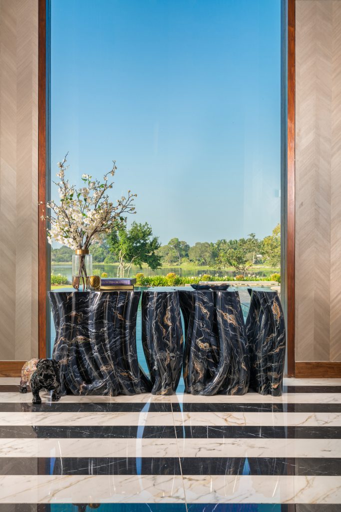 Luxury Residence in Sri Lanka, Monochrome console with sculptural marble effect positioned against a panoramic window overlooking the landscape