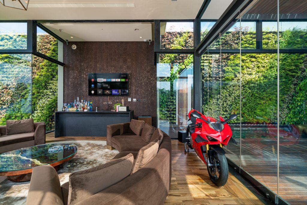 Luxury Residence in Sri Lanka, modern living room with sculptural center table, curved seating and luxury bar area with glass walls
