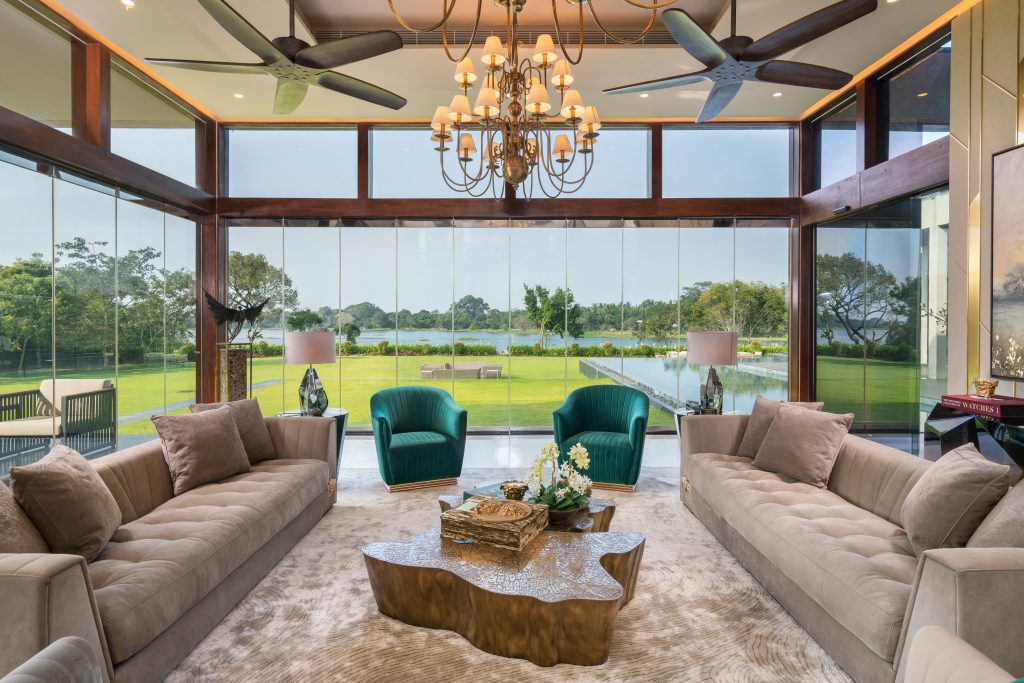 Luxury Residence in Sri Lanka, contemporary living room with Eden center table, velvet sofas and panoramic glass walls overlooking the landscape