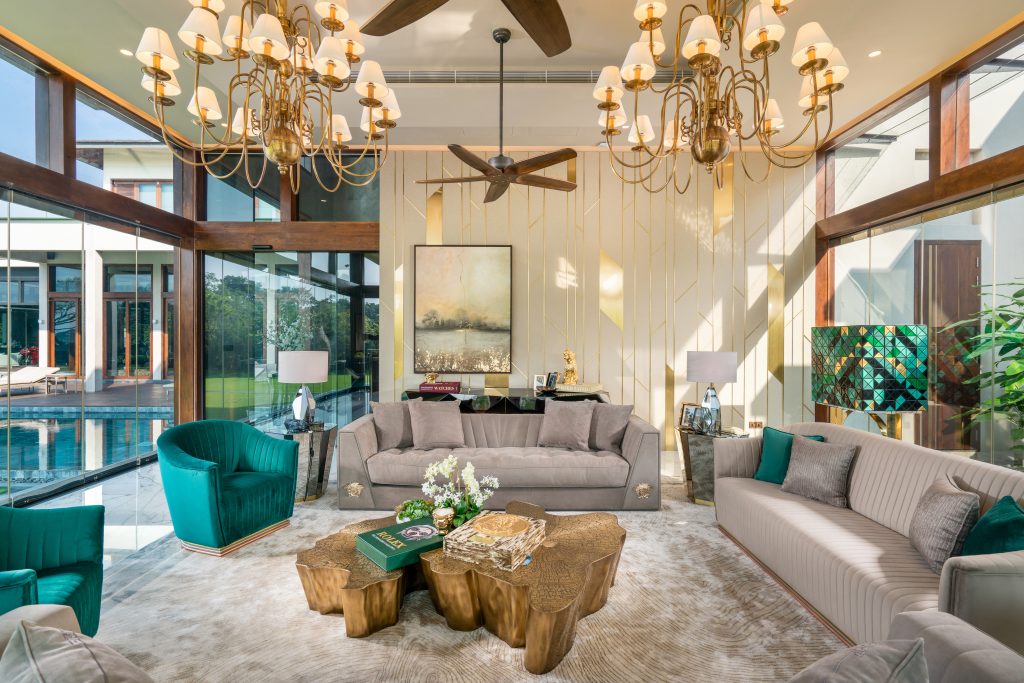 Luxury Residence in Sri Lanka, elegant living area with sculptural center table, green velvet armchairs and floor-to-ceiling windows