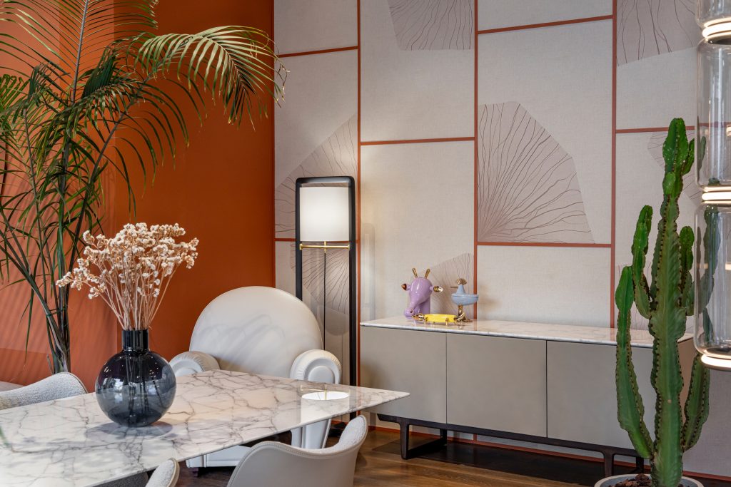 Boca do Lobo in Milan, contemporary dining interior with marble table, neutral upholstered chairs, geometric wall panels, and curated decorative objects creating a refined modern atmosphere.