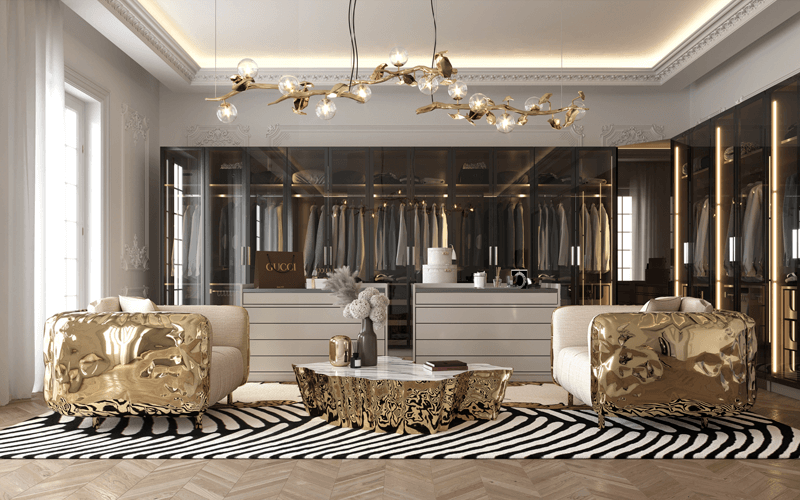 A luxury walk-in closet or dressing area featuring two armchairs with highly polished gold outer shells, a matching fluid gold coffee table, and a background of sleek, dark glass-front wardrobes., stone coffee tables
