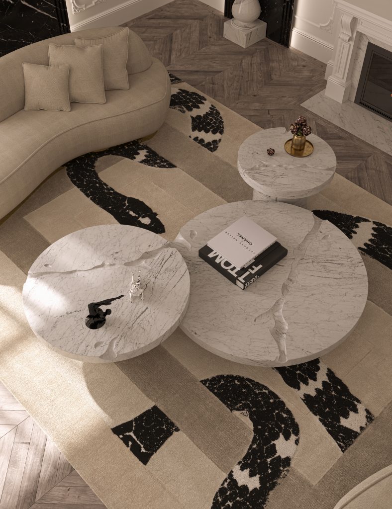 A top-down view of three interlocking round white marble coffee tables with natural texture cracks, placed on a patterned beige and black rug next to a curved sofa., stone coffee tables