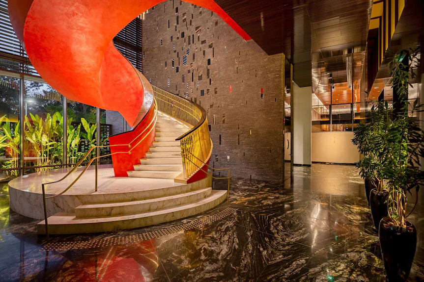 Luxury hotel lobby with red curved marble spiral staircase and gold handrail – melhores hoteis em sao paulo