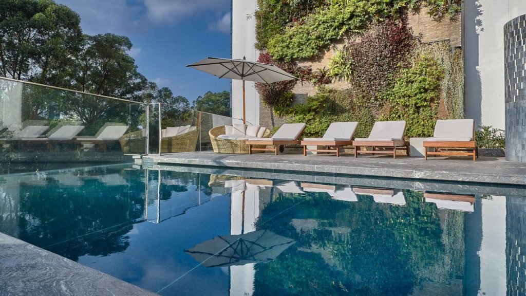 JW Marriott São Paulo outdoor pool surrounded by palm trees and lounge chairs – melhores hoteis em sao paulo