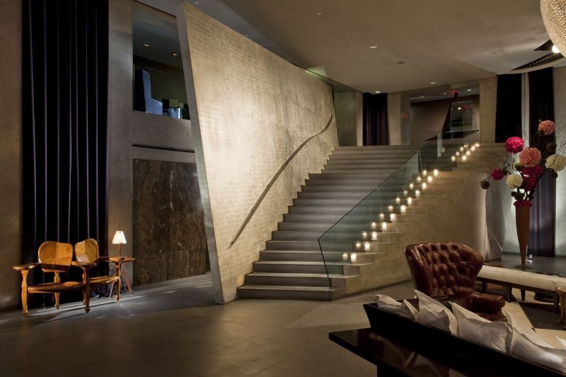 hotel paramount New York – Monumental staircase in sculpted concrete illuminated by candles, creating a dramatic and sophisticated atmosphere.