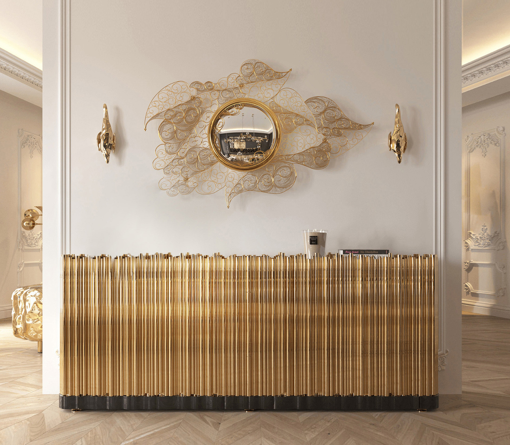 Luxury entrance foyer featuring the golden Symphony Sideboard, ornate Filigree Mirror, and two Soleil Sconce Wall Lamps against elegant white walls.