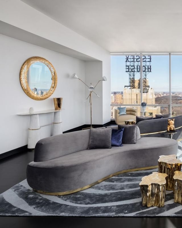luxury living room interior design with a grey sofa, a grey rug, golden mirror and golden center table