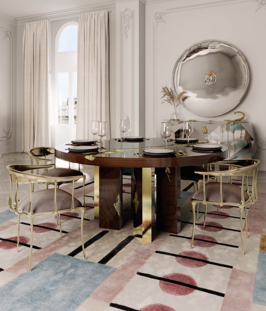 50 luxury dining rooms - luxury dining room with a round wooden dining table with gilded details, chairs with a gilded metal frame and grey fabric seat, a silver sideboard in the background that matches the wall mirror