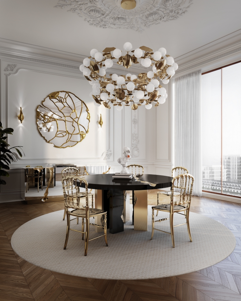 50 luxury dining rooms - luxury dining room, with a round wooden dining table with gold detailing, gold chairs, a round gold lamp and white bulbs, at the back of the room a silver sideboard with gold detailing and above it a round gold mirror with fragmented detailing