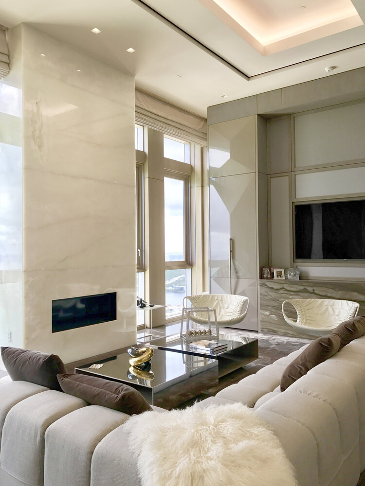 Spaces- luxury living room, cream big sofa, center table, fireplace and white armchairs