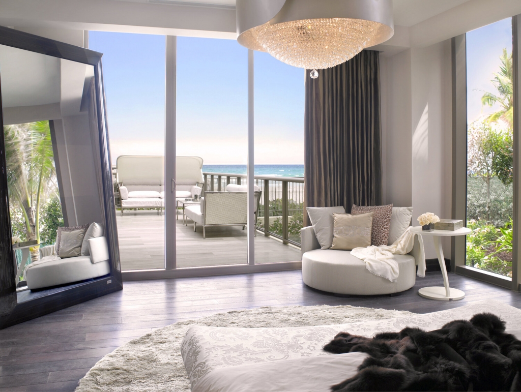 Spaces- luxury bedroom with sea view, white armchair, big mirror, white chandelier, white round rug