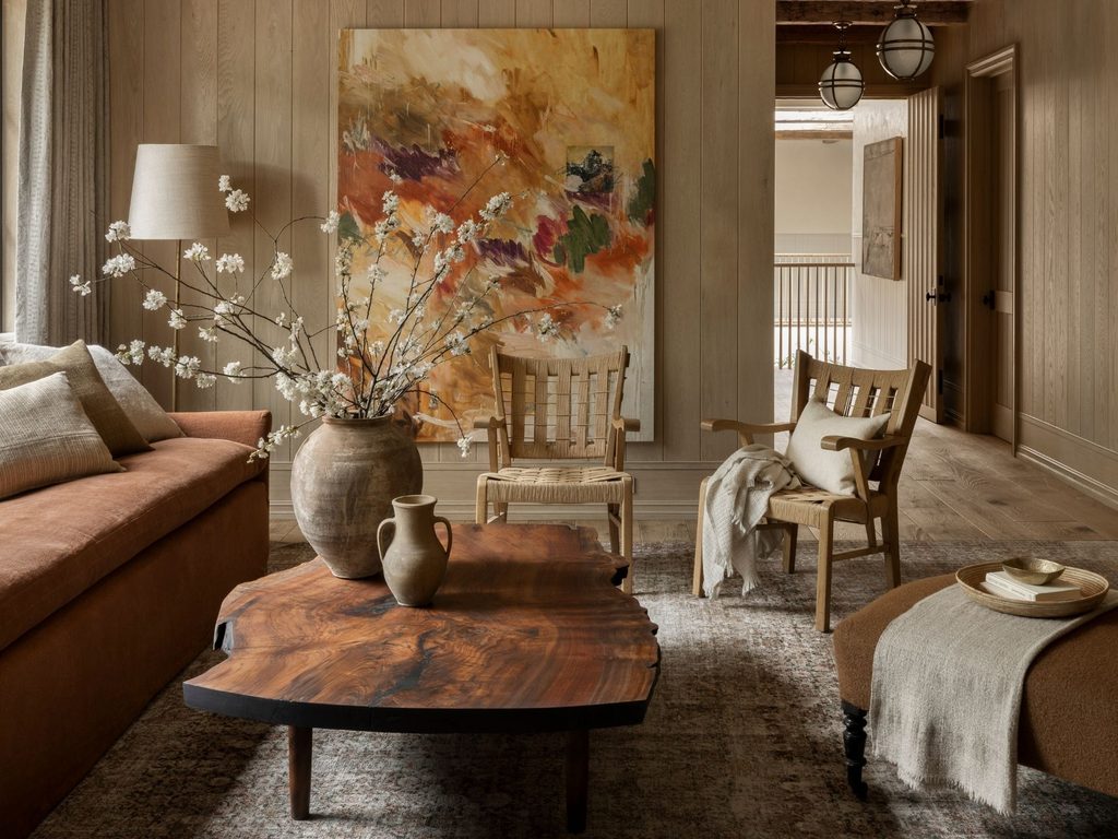 Warm living room with live-edge coffee table and large painting, interior designers