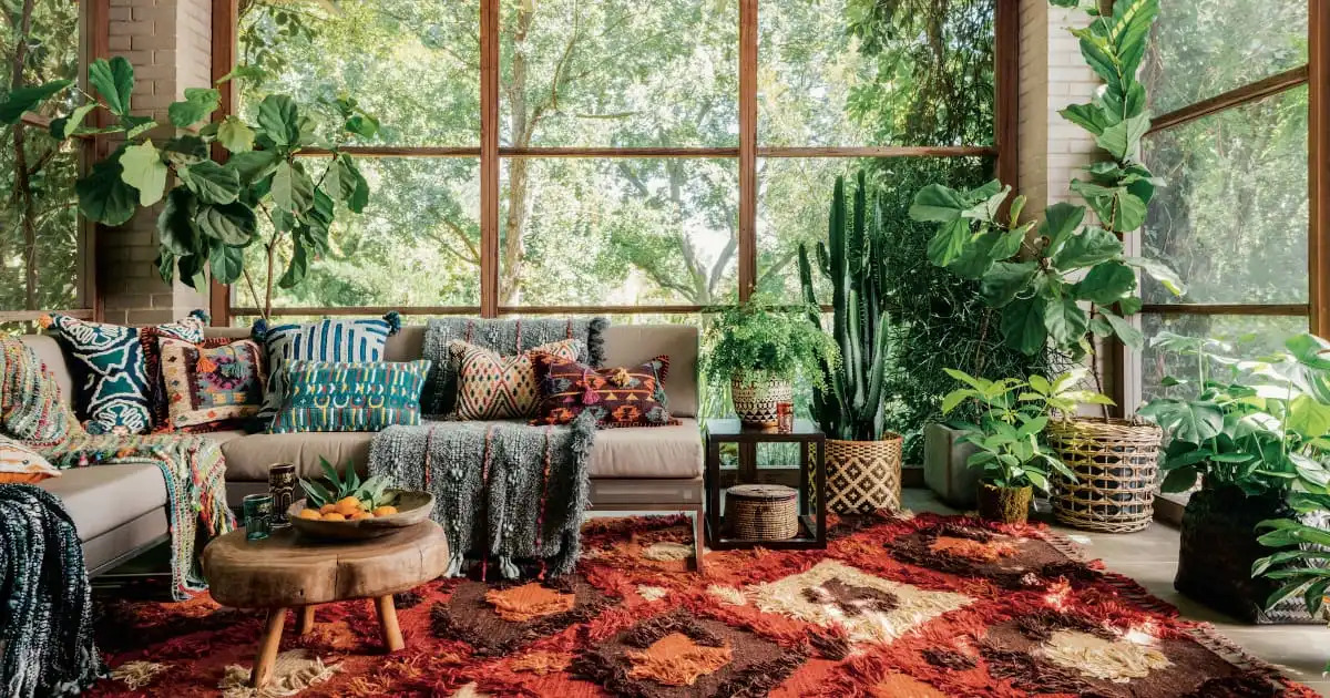 Eclectic indoor garden lounge with colorful textiles, interior designers