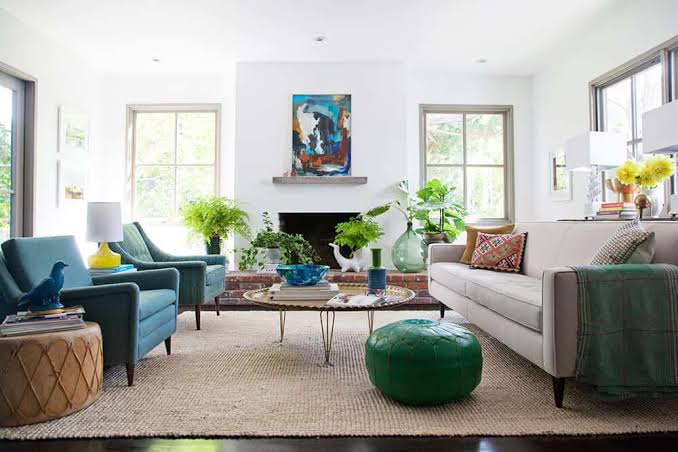 Bright living room with teal armchairs and fireplace, interior designers