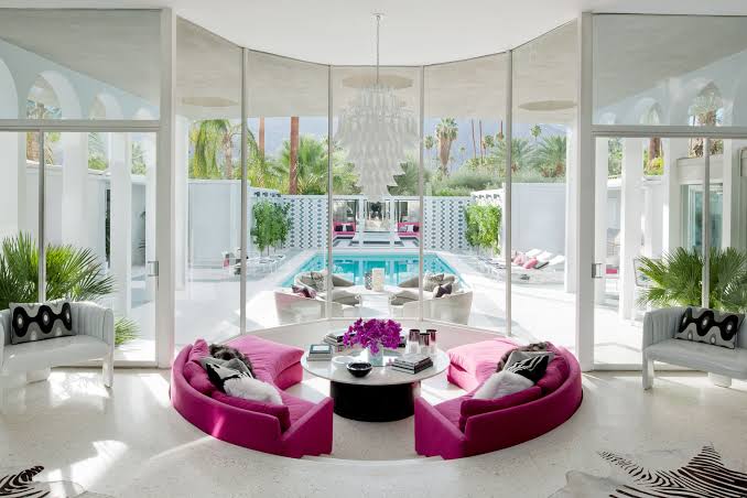 Modern luxury lounge with pink sofas and pool view, interior designers