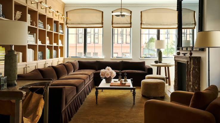 Cozy living space with brown sectional sofa and shelves, interior designers