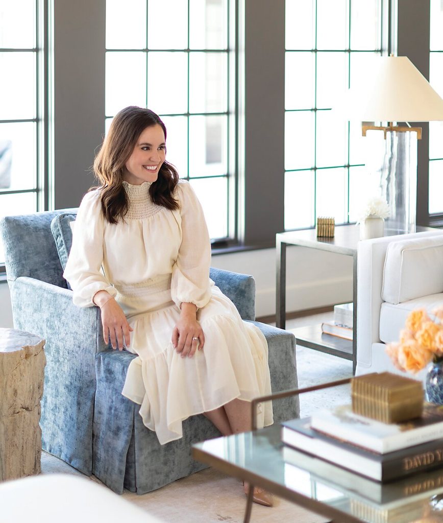 Designer sitting on a blue armchair in a bright room, interior designers