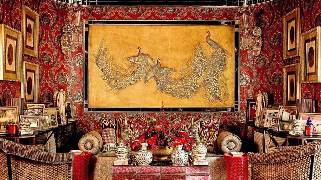 Opulent room with red wallpaper and art, luxury interior designers in India