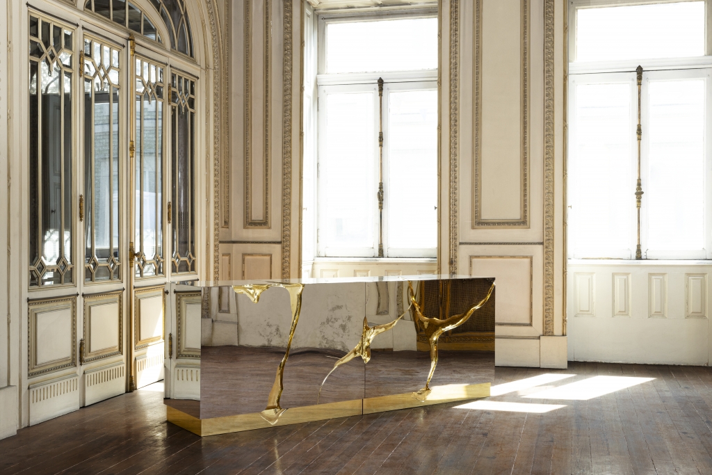 Houses of Royals- A luxurious mirrored sideboard with striking gold accents and organic, cracked-like details stands in an elegant, classical room with ornate moldings, tall windows, and wooden floors.