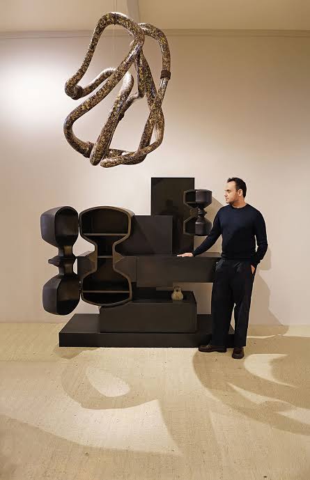 Designer next to modern black shelving unit, luxury interior designers in India