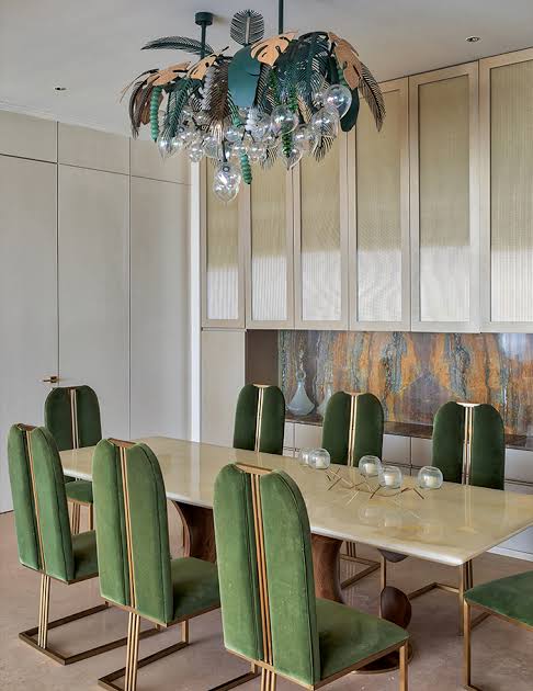 Dining set with green chairs and leaf lamp, luxury interior designers in India