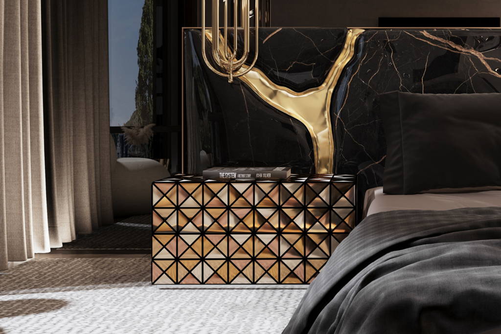 Modern bedroom with a geometric gold-toned nightstand and a striking black marble headboard featuring bold metallic accents, styled with books beside a neatly made bed.