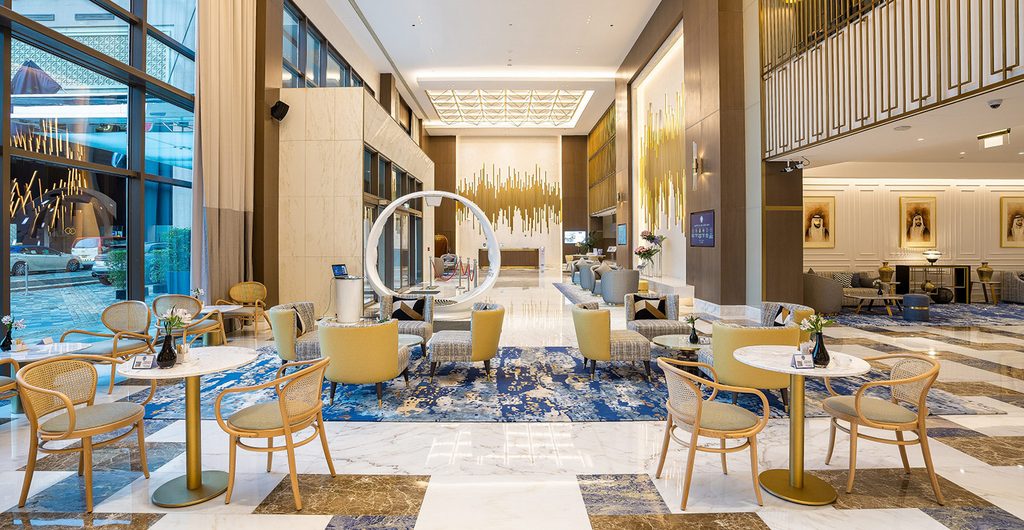 Spacious hotel lobby with marble floor and cafe seating, interior designers in Dubai