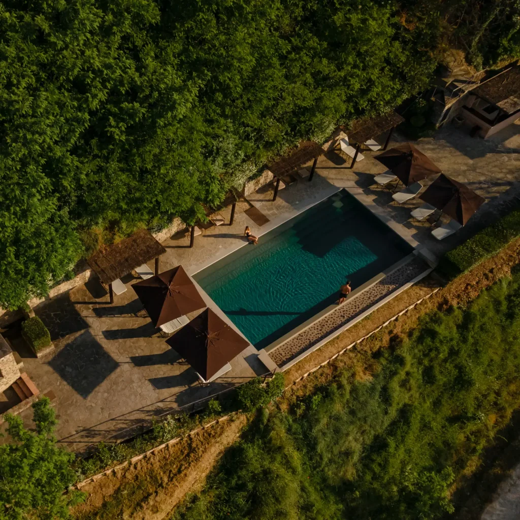 old money style, Historic Tuscan estate featuring restored stone buildings, vineyards, olive groves, and rolling countryside views.