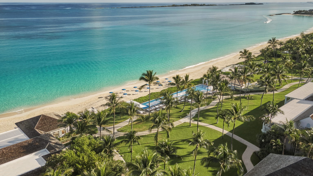 Four Seasons Hotels The Ocean Club A Four Seasons Resort aerial view showcasing the luxury hotel grounds, swimming pool, and private beach overlooking the turquoise ocean in the Bahamas.