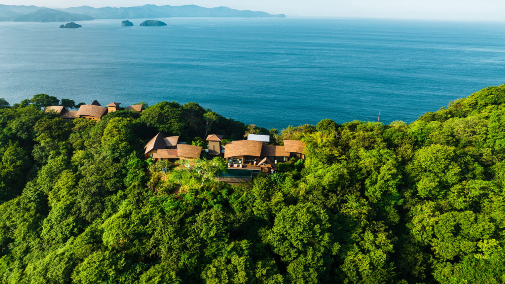 Four Seasons Hotels Resort Costa Rica at Peninsula Papagayo exterior view featuring luxury villas nestled among tropical trees with ocean views in Costa Rica.
