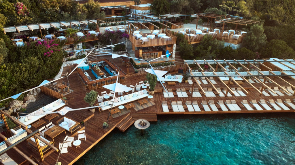 Luxury Beach Clubs: Exterior view of Maçakızı in Türkbükü, Bodrum, Turkey, featuring elegant waterfront terraces, luxurious sun loungers, and a sophisticated Aegean seaside atmosphere.