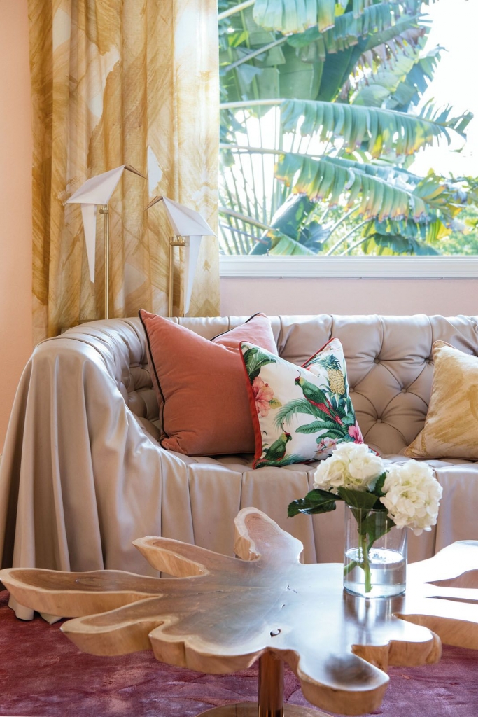 Nikki Hunt Interior Design, Living room with a wooden center table and a beige sofa with colourful cushions, featuring a tropical maximalist design style