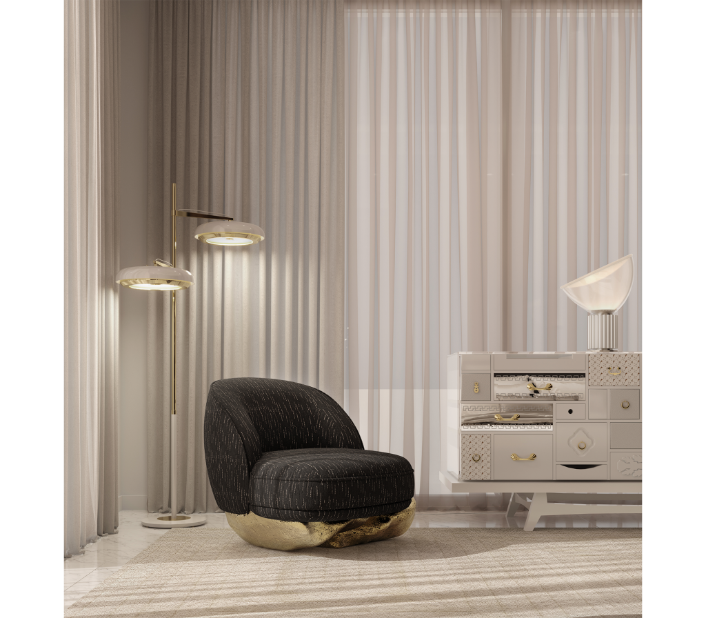 Black Angra armchair with a textured fabric seat and polished brass base placed in a refined modern interior with designer lighting, luxury armchair.