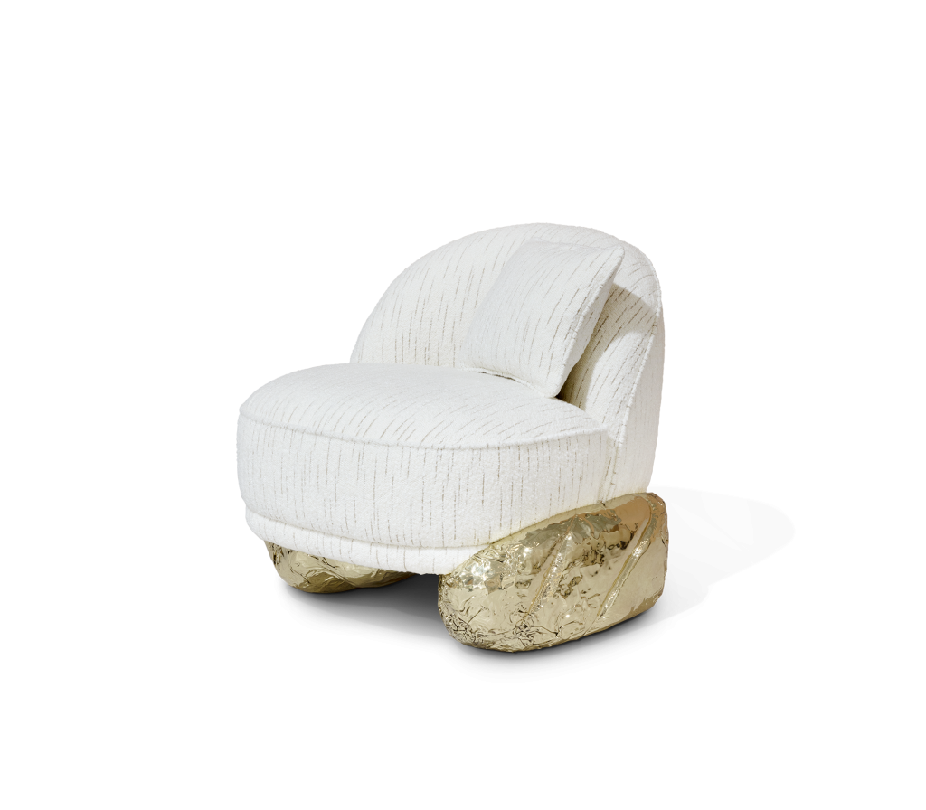 White Angra II armchair with textured upholstery and polished brass sculptural base isolated on a transparent background, luxury armchair.