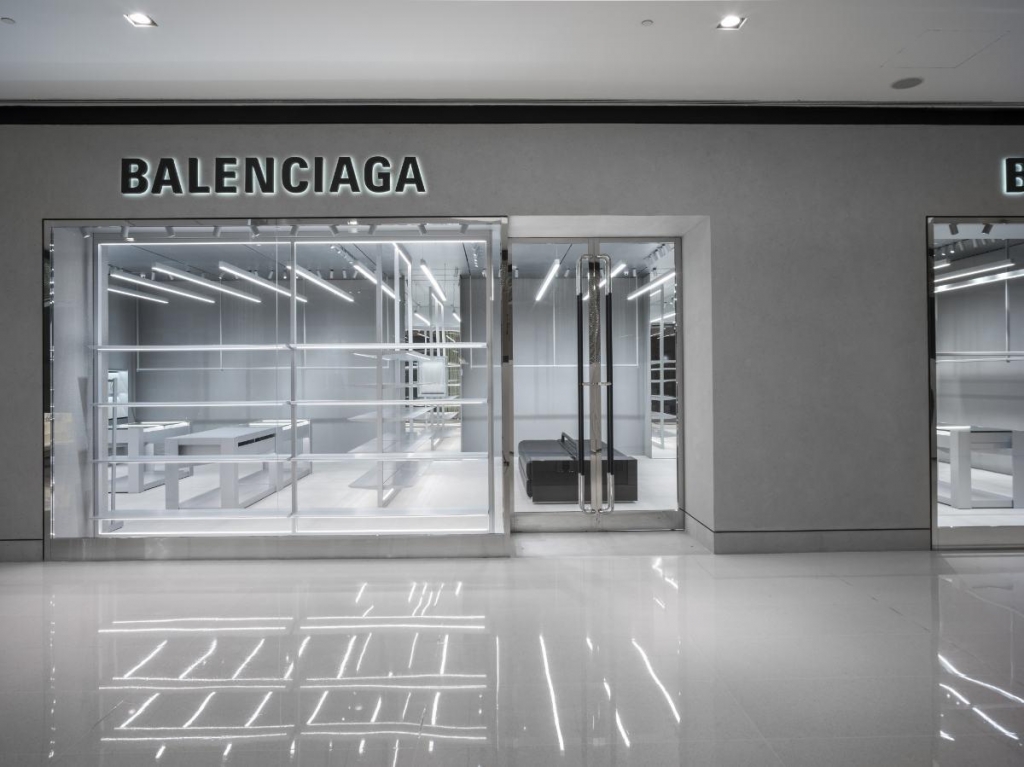 Interior minimalista da loja Balenciaga com prateleiras metálicas, iluminação em tiras de LED e piso reflexivo - lojas de luxo em São Paulo